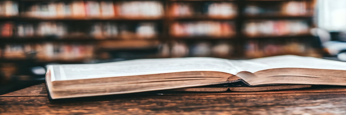 Aufgeschlagenes Buch vor einem Bücherregal