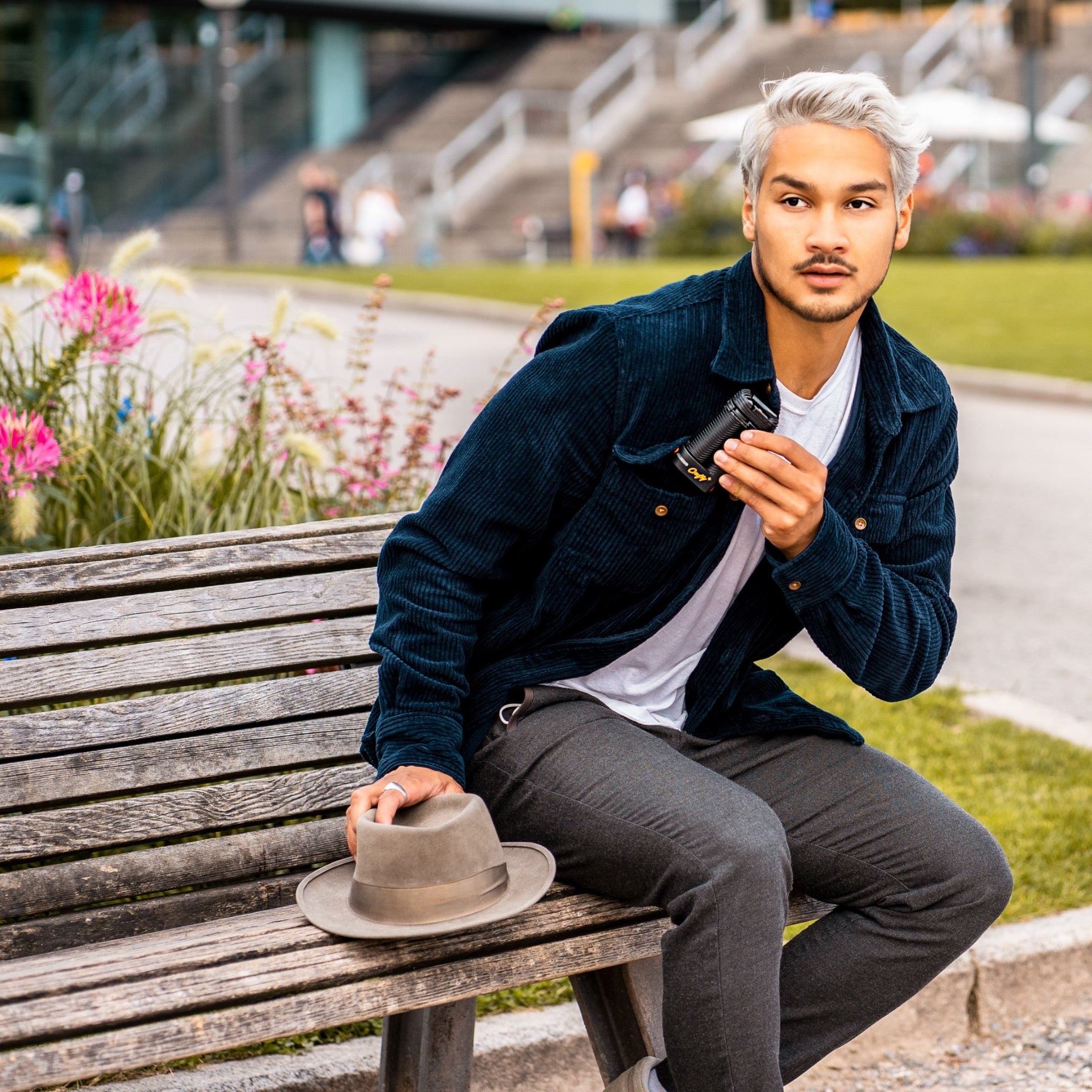 Storz & Bickel Crafty+ Lifestyle junger Mann sitzt auf Bank und hält den Crafty+ in der Hand