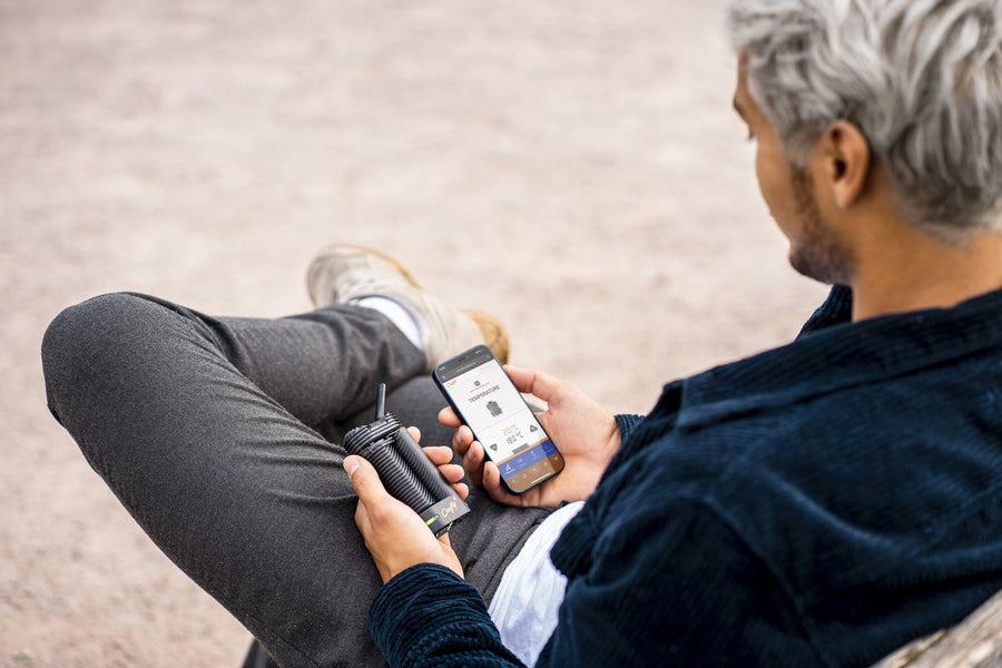 Mann mit Crafty+ Vaporizer und Smartphone